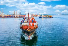 A cargo ship in port with numerous containers, symbolizing the increase in exports and diversification of the Brazilian livestock sector in the face of steep tariffs.