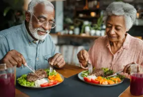 Older adults enjoying a healthy, high-protein meal, ideal for maintaining muscle mass in later life.