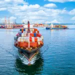 Un buque de carga en el puerto con varios contenedores, simbolizando el aumento de las exportaciones y la diversificación del sector pecuario brasileño ante el tarifazo.
