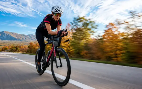 Recuperación tras el entrenamiento: ciclista en carretera abierta, pedaleando a gran velocidad durante un entrenamiento al aire libre.