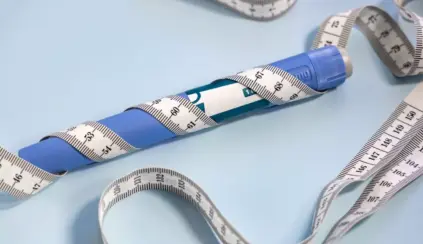 Caneta emagrecedora azul com fita métrica ao redor, instrumento popular para auxiliar na perda de peso e controle de medidas corporais.