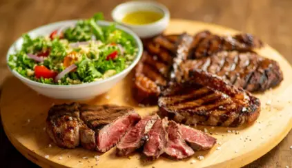 proteína bovina grelhada, acompanhado de uma salada verde fresca e molho