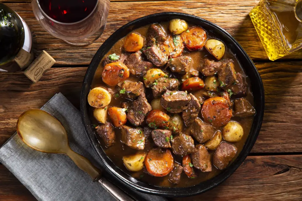 Prato de carne bovina cozida com cenoura, batata e temperos, destacando uma técnica de preparo que mantém a maciez e preserva nutrientes.