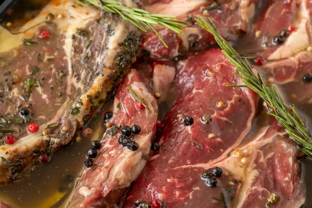 Beef cuts with a wet marinade of herbs, peppers and olive oil, ready to grill or roast, ideal for preparing dishes with wet marinades.