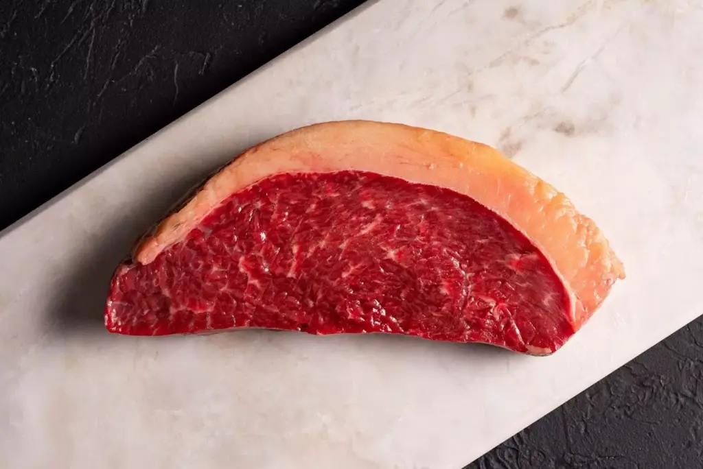 Carne bovina fresca e maturada, ideal para churrasco e preparo de pratos especiais, destacando sua textura e qualidade na montagem