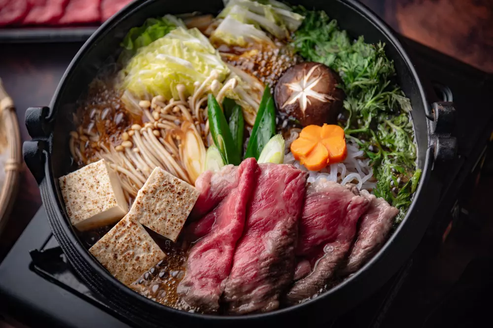 Prato de carne bovina brasileira acompanhado de vegetais e tofu, pronto para cozinhar em uma panela, representando a entrada do Japão no mercado de carne do Brasil