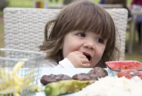 Criança desfrutando de carne bovina em refeição que promove o desenvolvimento cognitivo infantil