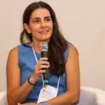 Luciana Haddad, falando com entusiasmo durante evento relacionado ao setor de agronegócio, destacando o papel das mulheres na atividade pecuária.