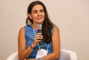 Luciana Haddad, falando com entusiasmo durante evento relacionado ao setor de agronegócio, destacando o papel das mulheres na atividade pecuária.