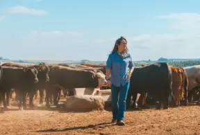 Mulher na pecuária se divertindo ao lado de gado em uma fazenda, evidenciando o papel das mulheres na atividade da pecuária, especialmente na pulqueria.