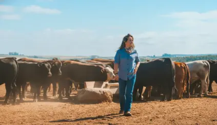 Mulher na pecuária se divertindo ao lado de gado em uma fazenda, evidenciando o papel das mulheres na atividade da pecuária, especialmente na pulqueria.