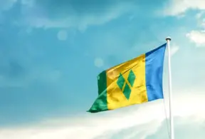 Bandeira do Caribe assoprando ao vento em um céu azul claro, representando o mercado de carne na região caribenha.
