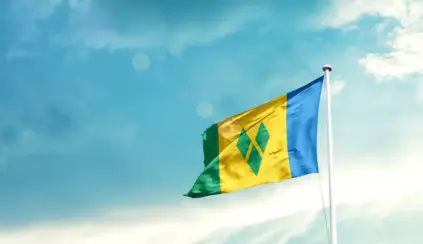 Bandeira do Caribe assoprando ao vento em um céu azul claro, representando o mercado de carne na região caribenha.