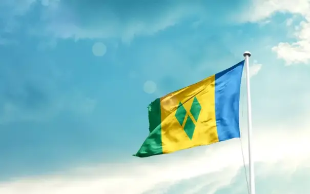 Bandeira do Caribe assoprando ao vento em um céu azul claro, representando o mercado de carne na região caribenha.