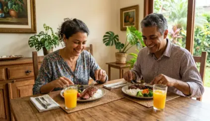 Casal sorridente almoçando prato com arroz, feijão, carne e legumes em representando o dia mundial da saúde.
