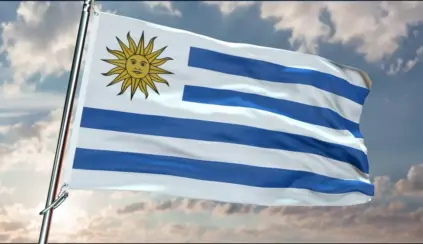 Bandeira do Uruguai hasteada sob céu nublado, representando as práticas de manejos de solo do país