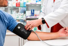 Médica verifica a pressão arterial em paciente com aparelho de pressão no braço, em ambiente clínico, tema relacionado a pressão alta e cuidados com a saúde.