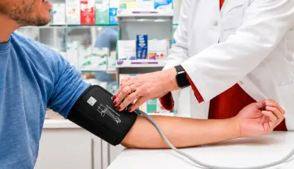 Médica verifica a pressão arterial em paciente com aparelho de pressão no braço, em ambiente clínico, tema relacionado a pressão alta e cuidados com a saúde.