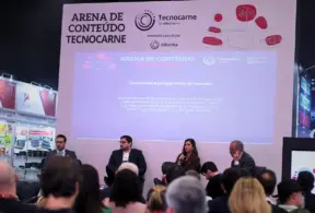 Palestra em evento Tecnocarnes com telão exibindo “Arena de Conteúdo Tecnocarn(e)” e tema de tendências e perspectivas do mercado da carne, com participantes sentados