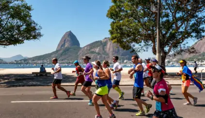 Os corredores participam de uma corrida ao longo da horla da praia. Os espectadores assistem de um banco, enquanto alguns discutem o que comer antes e depois de correr para otimizar seu desempenho e recuperação.