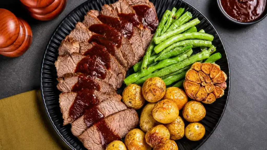Prato com porções de carne assada, brócolis e legumes, acompanhado de molhos em tigelas, ideal para entender a proteína no pré-treino e na alimentação do treino.