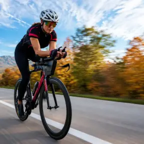 recuperación postentrenamiento: Ciclista en una carretera abierta, pedaleando a gran velocidad durante un entrenamiento al aire libre